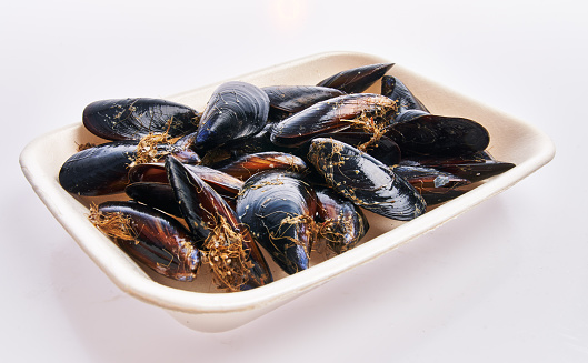 Tray of delicious mussels over white isolated background