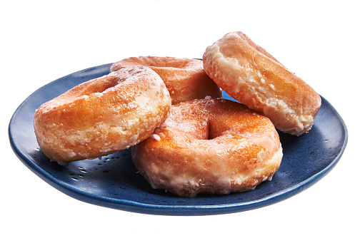 Plate of glazed doughnuts isolated over white background
