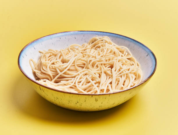 istock Plate of white spaghetti over yellow background 1396261122