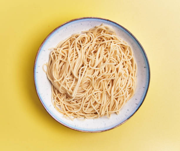 istock Plate of white spaghetti over yellow background 1396261123