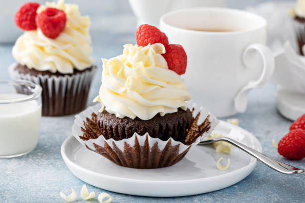 istock Chocolate cupcakes with white chocolate frosting and raspberries 1396261140