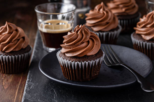 dunkle schokolade irish coffee cupcakes mit geschlagenem whisky ganache frosting - cupcake chocolate icing candy stock-fotos und bilder