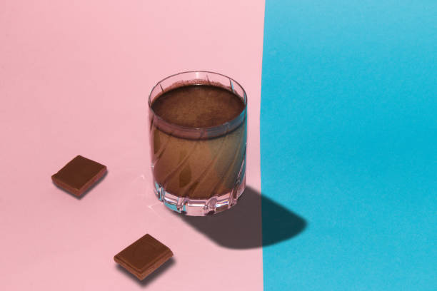 istock glass black chocolate coffee and two chocolate cubes for pink-blue background, creative summer chocolate design 1396261669