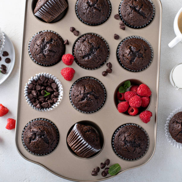 istock Chocolate muffins in a muffin pan with raspberries 1396261733