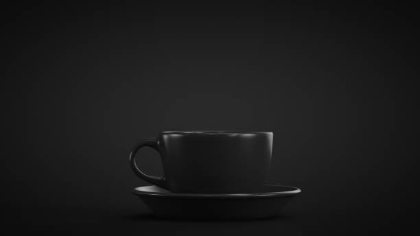 Black mug with a saucer on a black background. Close-up