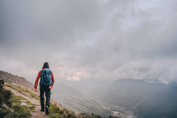 istock Hiker walking on the high mountain trail, cloudy sky 1396269683