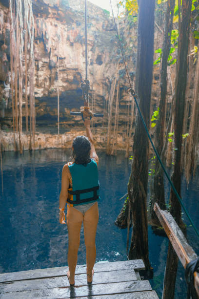 istock Woman on rope swing in cenote 1396272782