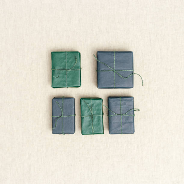 istock Holiday handmade gift boxes, square pattern on linen cloth background, green, blue paper-wrapped presents with rough thread, minimal aesthetic flatlay colorful gifts cute simple presents 1396272993