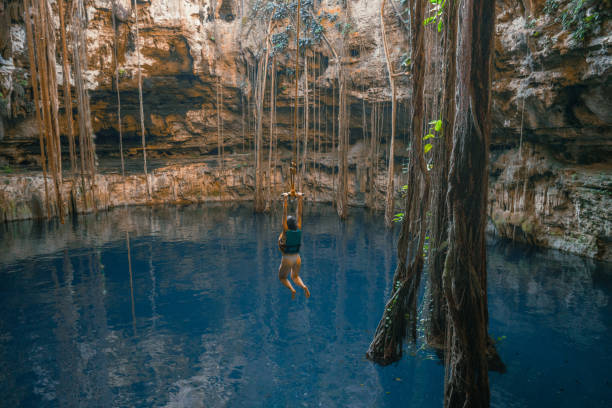 istock Woman on rope swing in cenote 1396274780