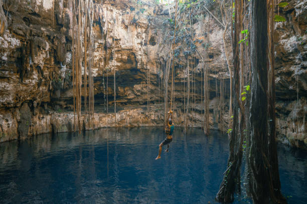 istock Woman on rope swing in cenote 1396274783