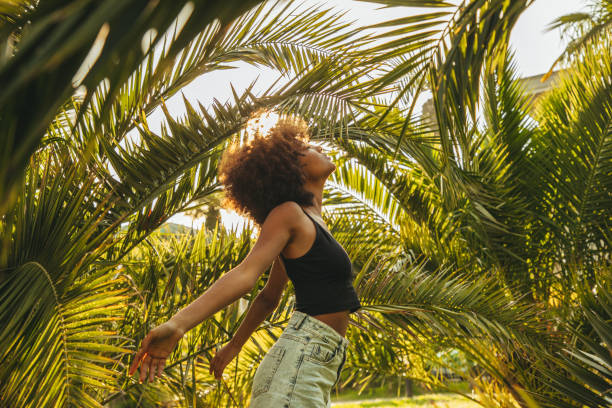istock Pretty young afro woman among palm trees 1396276330