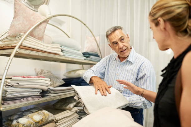 Senior interior design consultant helping client in making fabric choices in his shop