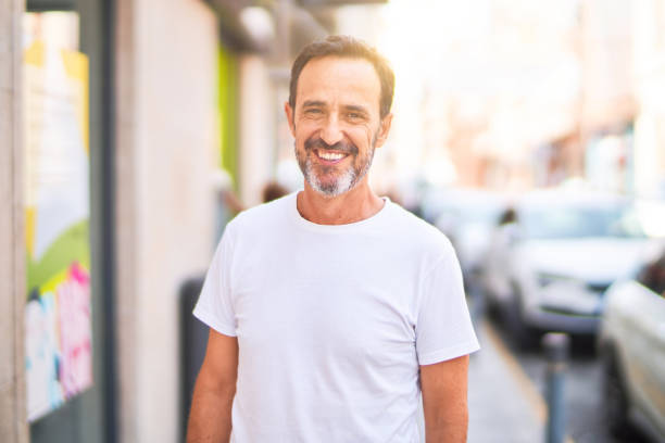 istock Middle age handsome man standing on the street smiling 1396277054