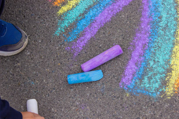 istock A child draws a rainbow on the asphalt. Selective focus. 1396278694