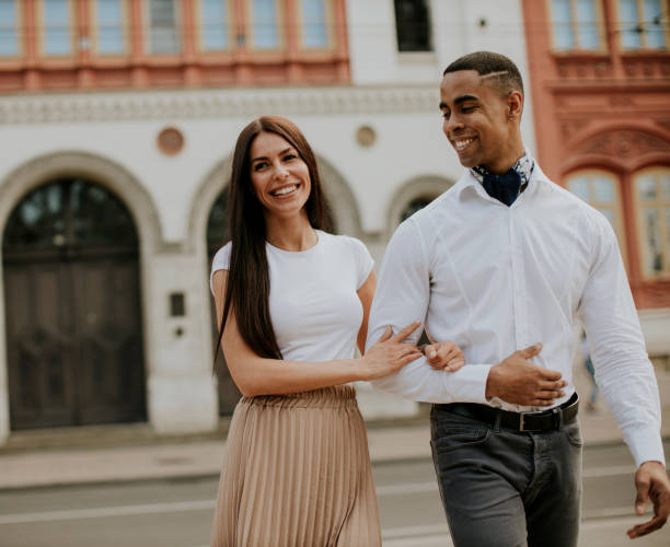 istock Young multiethnic couple walking on the street 1396281868