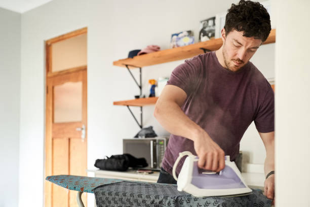 istock Man ironing his shirt in living room 1396282305