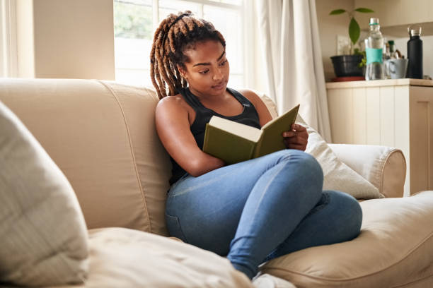 istock African woman reading a book at home 1396282453