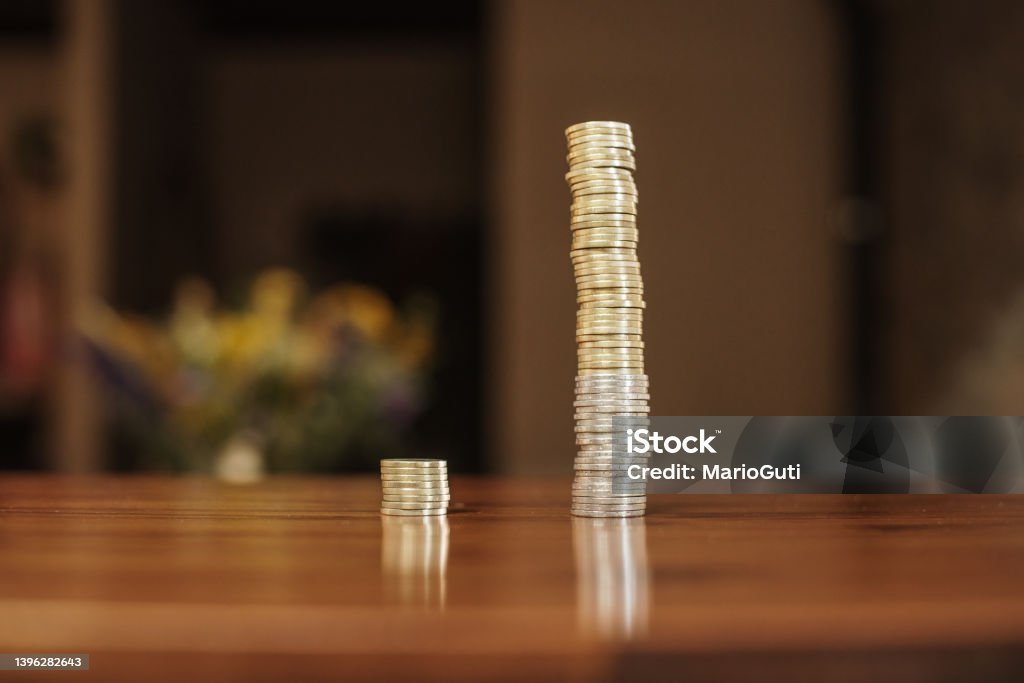 Two coin stacks with very different size Two stacks of coins with very different size - Inequality concept Currency Stock Photo