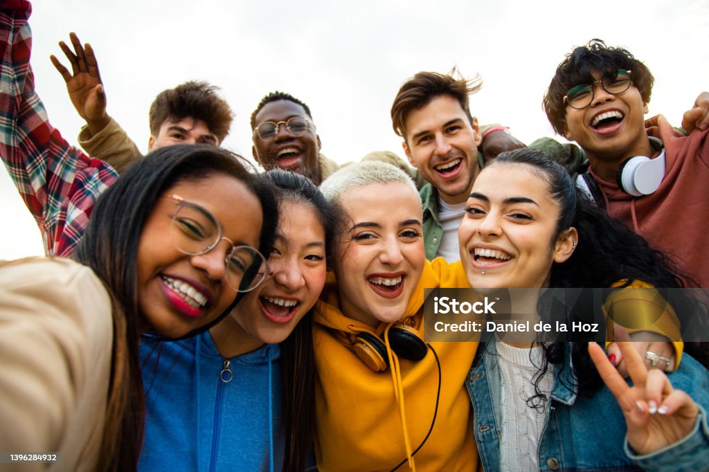 Group of multiracial teen college friends having fun outdoors. Happy people taking selfie. Group of multiracial teen college friends having fun outdoors. Happy people taking selfie. Gen z, friendship and technology concept. Teenager Stock Photo