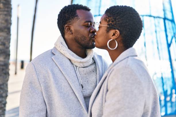 couple d’hommes et de femmes debout ensemble s’embrassant dans la rue - couple black american culture kissing photos et images de collection