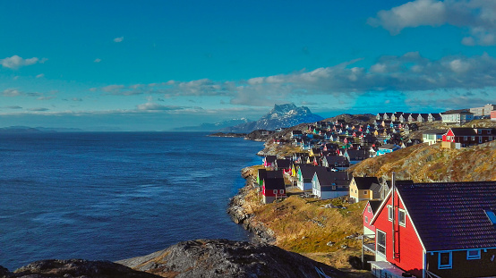Colorful houses in Nuuk facing a fjord
with mountains in the horizon
