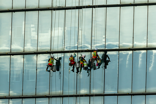 Ho Chi Minh City, Vietnam - ‎‎‎‎‎December 24, 2020 : Group Of Workers Cleaning Windows And The Glass Facade Of A Modern Office Building.