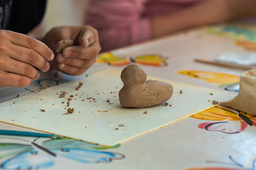a child makes clay crafts with his hands