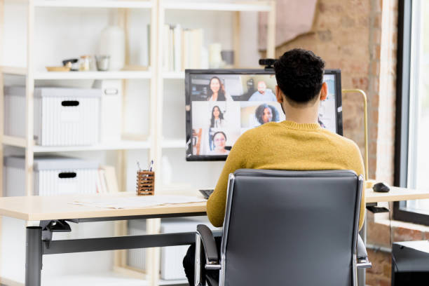 istock Rear view unrecognizable man attending online meeting from home 1396288939