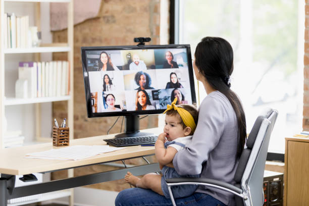 istock Work-from-home mom holds baby while attending meeting 1396288951