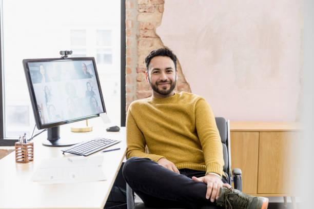 istock Man takes break from online meeting to smile for camera 1396288962
