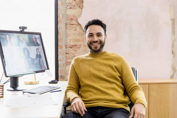 istock Relaxed man turns and smiles for camera during online meeting 1396288963