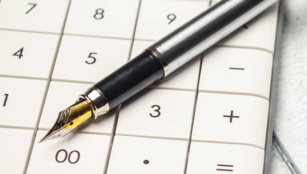 istock Calculator, pen and eyeglasses on wooden table 1396289216