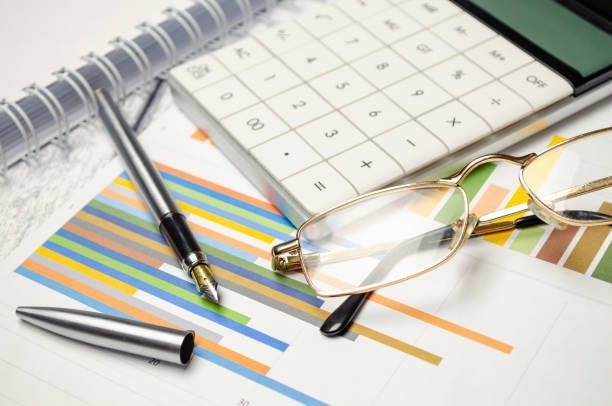 istock business objects - graphs, charts, pen and calculator on the table 1396289253