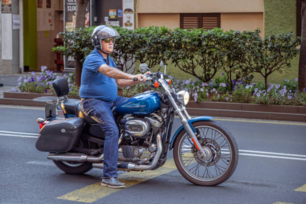 Elderly man with a crash helmet on a motor bike in Santa Cruz which is the main city on the Spanish Canary Island Tenerife
