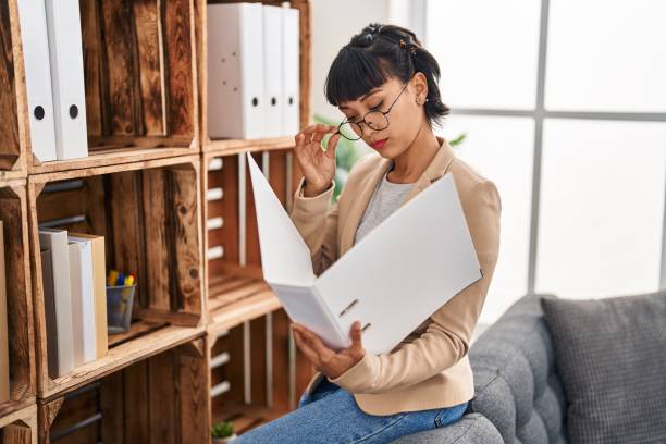istock Young woman business worker reading document at office 1396290178