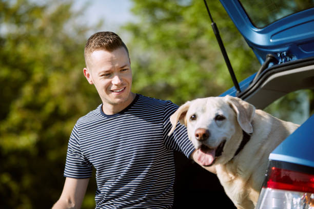 istock Man with dog traveling by car 1396290957