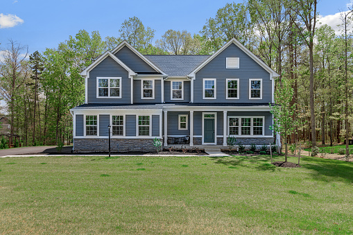 Front exterior of a large greyish blue new home in Virginia.