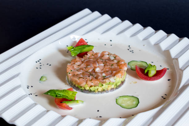 istock salmon Tartar on a white plate on dark table 1396292258