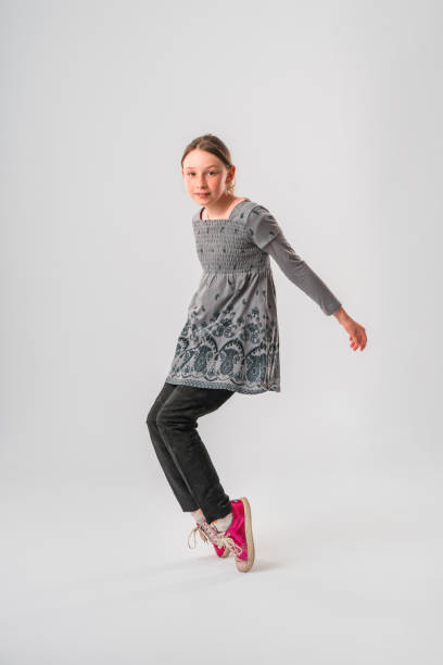 caucasian teenage girl standing on toes in studio - arms outstretched teenage girls jumping flying imagens e fotografias de stock