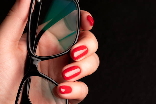 istock Hand with red nails and glasses 1396293465