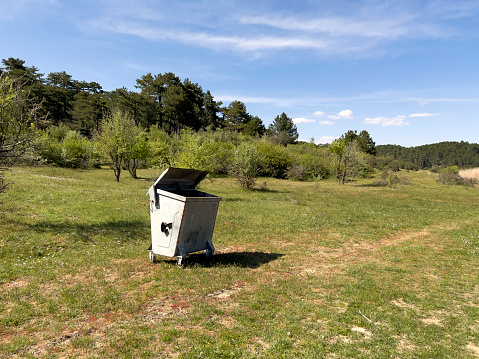 Barcelona, Spain - January 10th, 2017: Recycling of garbage in Barcelona. There are public recycling containers in five colours: Yellow for plastics, green for glass bottles, blue for paper an cardboard, brown for organic garbage, and grey for general trash.