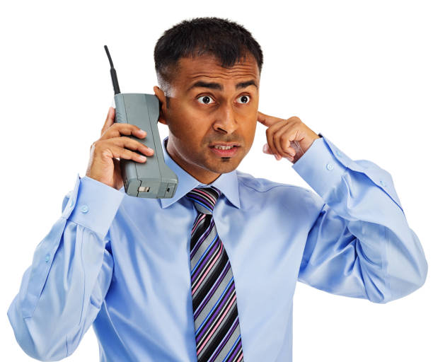 Photo of an Indian businessman trying to conduct a conversation on an antiquated \