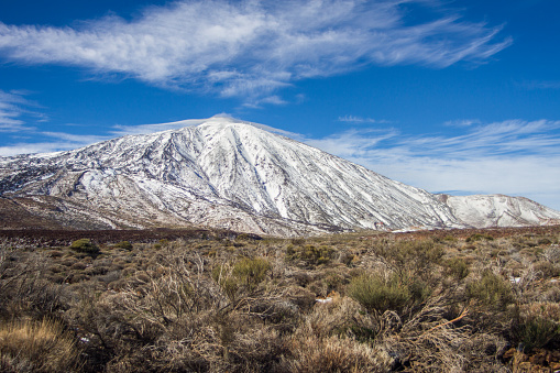 Landscape of the snowy Teide volcano in winter, with blue sky with some white clouds. Las Cañadas National Park. Tenerife, Canary Islands, Spain