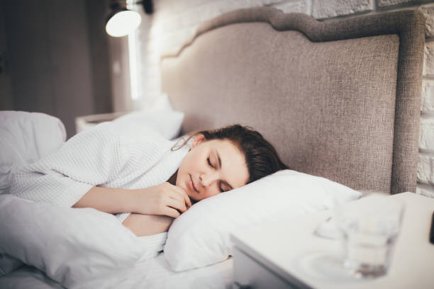 istock Young woman sleeping in her bed with white linen. 1396296289