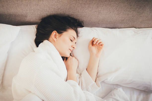 istock Young woman sleeping in her bed with white linen. 1396296291
