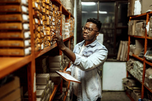 istock Casually clothed businessman checking items on his digital tablet in a distribution warehouse 1396297007