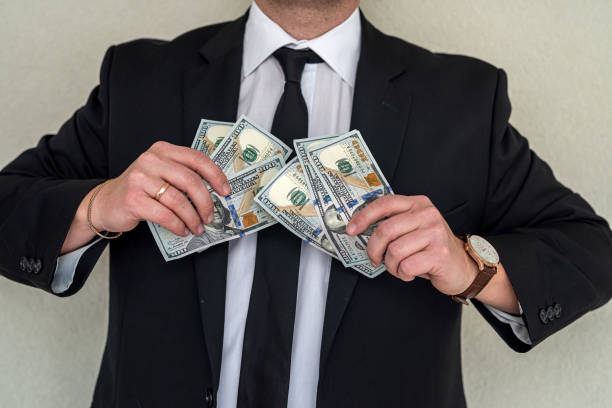 istock rich man in business style counting money 1396297594