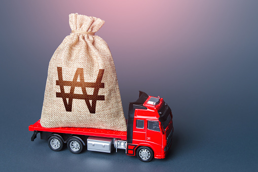 Truck with a south korean won money bag. Compensation. High super income. Payment of taxes. Debt load. Money transfers and transactions. Loan or deposit. Financial aid, investments and subsidies.