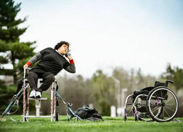 Photo of Senior disabled Latin lady practising shot put