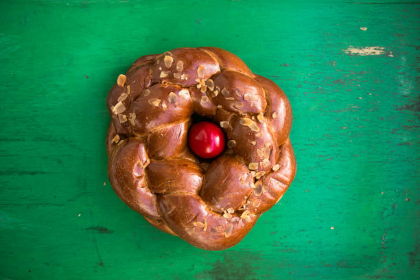 Tsoureki traditional baked Greek Easter sweet bread, garnished with slivered almonds and decorated with a boiled red dyed egg in the middle stock photo